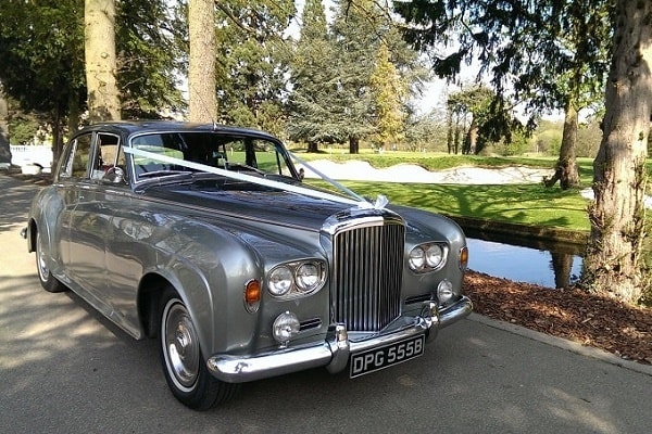 Our Silver Bentley S3 wedding car decorated with ribbons and bows